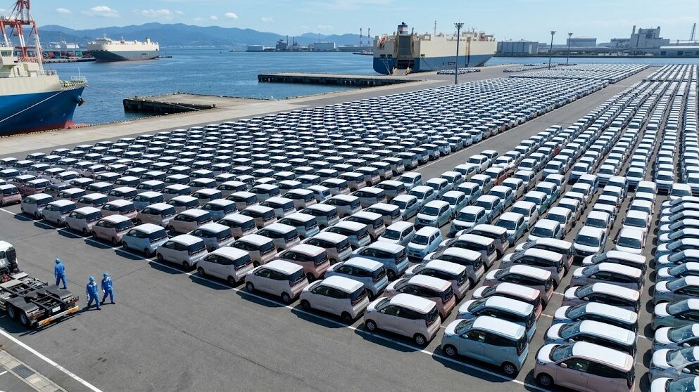 広大な自動車保管ポートに、整然と並べられたピカピカの登録済未使用車の日産サクラ